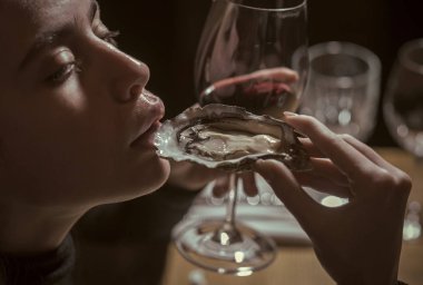 Kadın yüzü. Kızlar etkileyen konular. kız ya da kadın yeme istiridye lüks restoranda şarap ile. kadın veya kız yemek el istiridye ve kırmızı şarap içmek