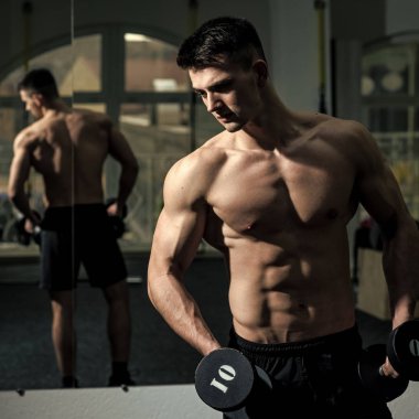 Erkek yüz. Çocuk etkileyen konular. Sporcu atlet kaslı çekici görünüyor. Gövde, kas maço ve onun yansımanın ayna arka planda olan adam. Spor salonunda çıplak gövde adamla zevk onun sportif