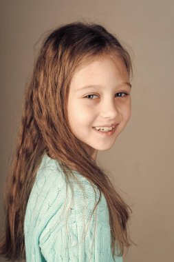 Bir gülen bir portre gri arka plan üzerinde küçük kız moda. Yüz moda küçük kız ya da çocuk web sitenizde. Senin advertisnent küçük kız yüz portre.