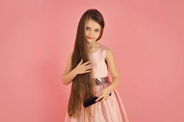 Cara de moda niña o niño en su sitio web. niña cara retrato en niña cepillo pelo en vestido de moda en rosa . — Foto de Stock