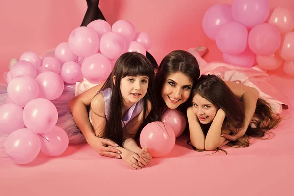 As crianças enfrentam cuidados com a pele. Cara de menina retrato em seu advertisnent. Jovens meninas felizes com a mãe com balões rosa — Fotografia de Stock