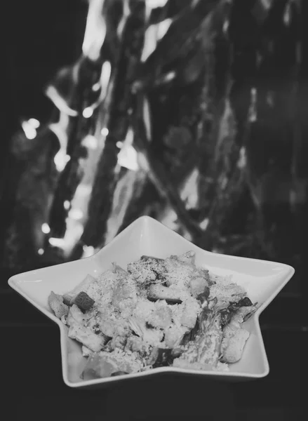 Caesar salade geserveerd in witte plaat in de vorm van sterren. Traditionele maaltijd in het restaurant - Caesarsalade, het vuur op de achtergrond. Schotel restaurantconcept — Stockfoto