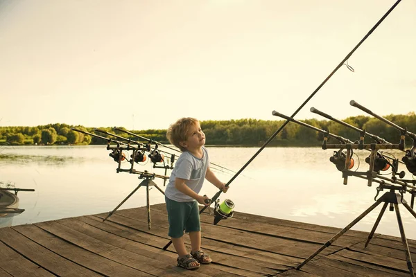 Chico feliz divirtiéndose. Niño pescador con caña de pescar en muelle de madera —  Fotos de Stock