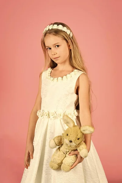 面对时尚的小女孩或孩子在您的网站。小女孩脸上的肖像在你的 advertisnent。快乐的年轻女孩穿着白色礼服与野兔玩具. — 图库照片