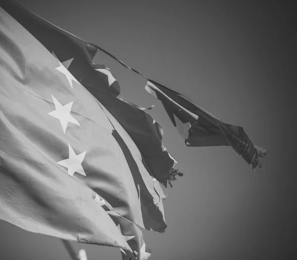 Unión Europea bandera de doce estrellas desgarrada y con nudos en el viento sobre el fondo del cielo azul, de cerca. La bandera es arrancada a un lado, símbolo de problemas, decadencia, desintegración, descomposición, ruptura —  Fotos de Stock