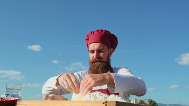 Bärtiger Koch, der an frischer Luft kocht. Bäcker beim Brotbacken. Bäcker knetet den Teig — Stockvideo