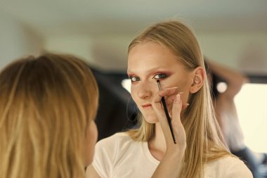 Glamour göz makyajı, bak gittikçe kadın. Makyaj sanatçısı uygulamak göz farı fırçası ile son saatlerinde yanında bulunanlar. Genç yüz cilt güzellik salonu içinde olan kadın. Dergi kapağı kız yüz. Kız yüz portre,