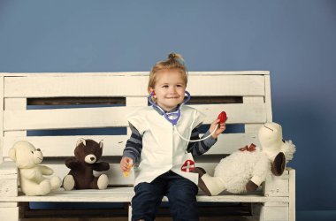 Oyuncaklarla oynayan çocuklar. Evcil hayvan tahta bankta oturmak oyuncak ile mutlu çocuk