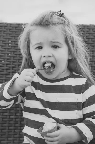 Dziecko jeść lody w kubek z miarką — Zdjęcie stockowe