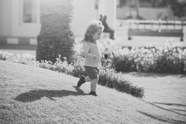Boldog gyerek szórakozik. Kis imádnivaló gyermek futás-on rét — Stock Fotó