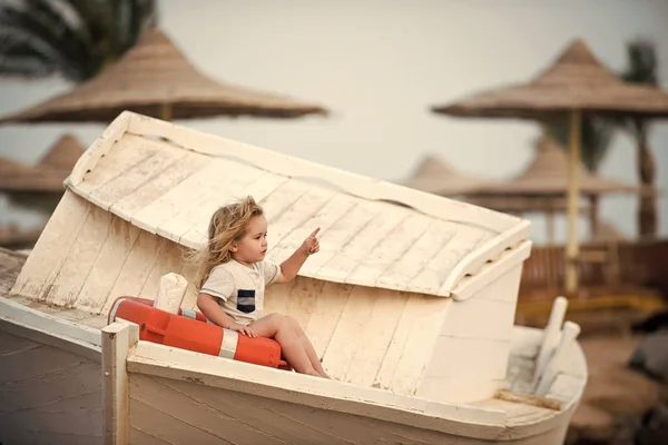 Happy kid having fun. Child little boy little sitting in life buoy on boat.