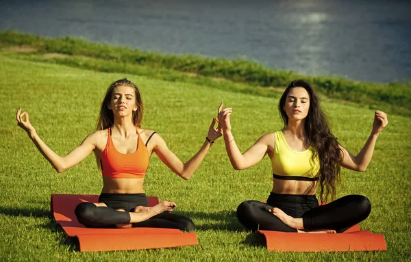 Cuidado de la piel de las mujeres. Retrato que las mujeres enfrentan en tu anuncio. Mujeres atractivas entrenando en hierba verde, deporte —  Fotos de Stock