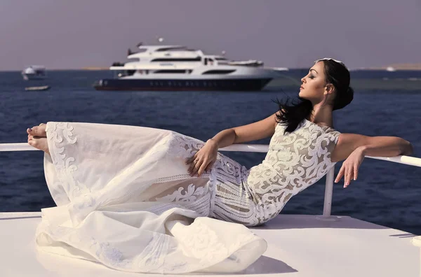 Sensuell kvinna. Kvinna brud i brudklänning avkopplande på yacht i havet — Stockfoto
