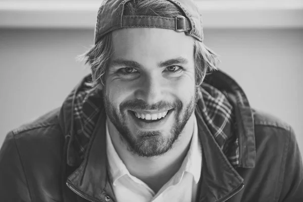 Fashion model Man fece close up. Face Man wiht happy emotion. Man with smile on bearded face wear baseball cap