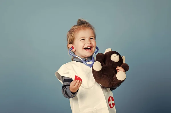 Kinderen spelen met speelgoed. Gelukkig kind dierenarts glimlach met teddybeer op blauwe achtergrond — Stockfoto
