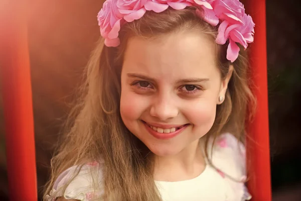 Щаслива дитина розважається. Маленька дівчинка з квіткою у волоссі, дитинстві та щасті . — стокове фото
