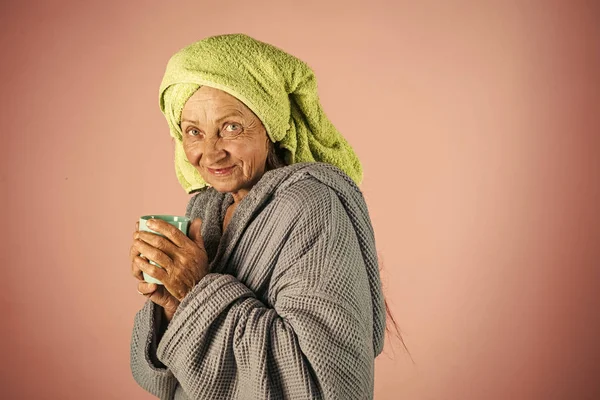 Velha senhora em turbante toalha com copo. Aposentadoria e pensão . — Fotografia de Stock