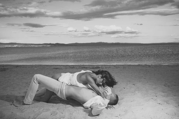 Un par de secretos de fantasía. Sexo en la playa concepto. Pareja enamorada tener sexo, hace el amor en la playa de arena. Pareja llena de deseo tener relaciones sexuales en la arena de la orilla del mar. Amantes sensuales haciendo el amor en la orilla del mar, mar en —  Fotos de Stock