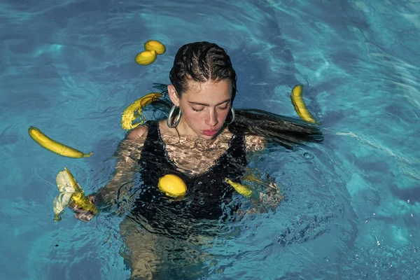 Frau Gesicht Schönheit. schöne junge Mädchen schwimmen mit Banane und Zitrone am Pool. — Stockfoto