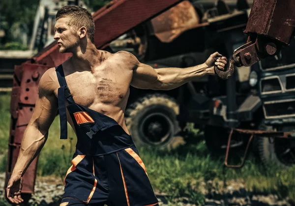 Boy Powered. Issues face boys. Bodybuilder with muscle chest, hands, biceps, triceps pull iron crane — Stock Photo, Image