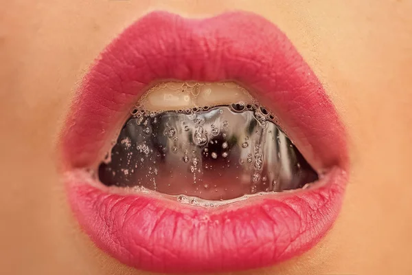 Closeup of sexual open female mouth of beautiful young lady with foam bever...
