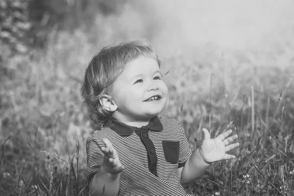 Mode ung grabb modell flytten närbild. Ansikte kvinnliga kid med glad känsla. Lycklig pojke på gräs — Stockfoto