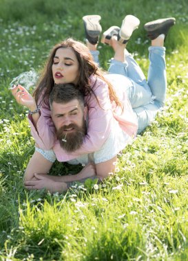 İki yeşil çim üzerinde yalan aşık. Seksi kız Sigara İçilmeyen, yüzünde, sağlıksız alışkanlık tiksinme ifadesi ile sakallı adam. Kaslı adam, piknik açık havada üstüne güzel kadın.