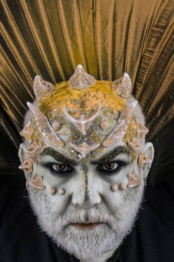 Dikenler veya siğiller, baş yüz pırıltılar ile kaplı, yakın çekim. İblis altın yaka, siyah arka plan ile. Uzaylı, iblis büyücü makyaj. Sakallı canavar makyaj ile komuta sizde. Fantezi kavramı.