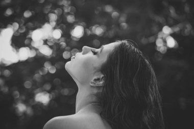 Saç bakım, tedavi ve tedavi. Kıvırcık saç modeli ve çıplak omuz yaz gününde olan kadın. Doğa üzerinde uzun esmer saçlı kadın. Kız makyaj yüz, güzellik. Moda model glamour bakışla