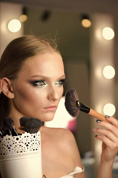 Mulher bonita aplicando pó de fundação ou blush com escova de maquiagem — Fotografia de Stock