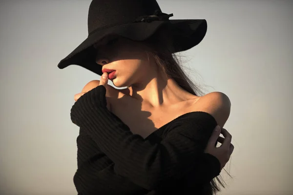 Kadın yüz güzellik. Siyah elbise ve mavi gökyüzü arka plan üzerinde geniş şapka zarif güzel kadın portresi — Stok fotoğraf