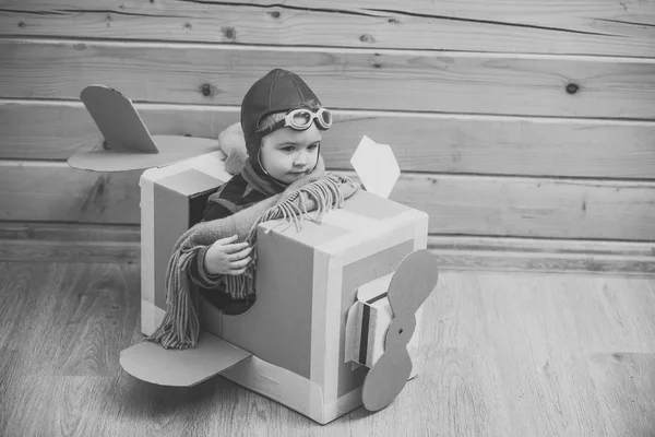 Les enfants jouent avec des jouets. Petit garçon mignon jouant avec un avion en carton — Photo