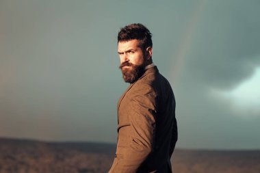 Yakışıklı adam yüz. Hipster gökkuşağı gökyüzü önünde şık görünümü ile.