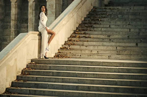 Cuidado de la piel de las mujeres. Retrato que las mujeres enfrentan en tu anuncio. Hermosa novia en vestido largo blanco posando en escaleras de mármol antes de la ceremonia de boda, novia sexy de pie en el vestido de escalera —  Fotos de Stock