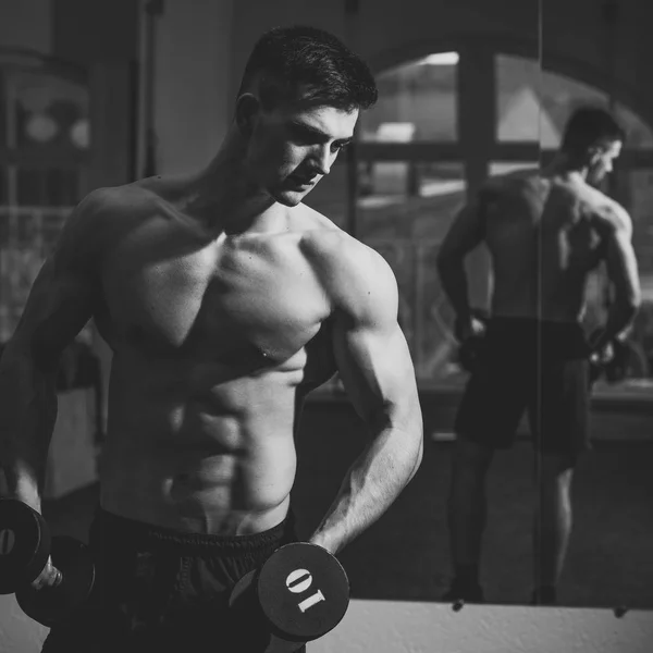 Man met naakte torso in sportschool geniet van zijn sportieve levensstijl. Sport en fitness concept. Sportman, atleet met spieren ziet er aantrekkelijk uit. Man met torso, gespierde macho en zijn reflectie in de spiegel achtergrond. — Stockfoto