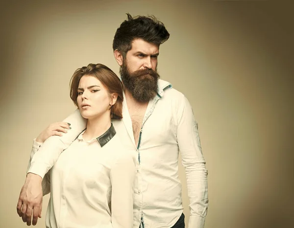 Sensual young couple making love. Couple in love. Barbershop concept. Fashion shot of couple after haircut. Woman on mysterious face with bearded man, light background. Man with stylish beard and