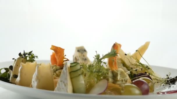 Закусочная с сыром из разных сортов сыра, украшенная петрушкой из оливкового ореха и салата . — стоковое видео