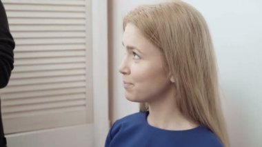 Makyaj sanatçısı için çekici bir genç kadın makyaj uygulamak. Makyaj genç kız için. Genç kız güzellik salonu. Seksi sarışın güzellik salonu