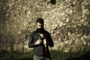 Ciddi adam. Taşlı duvar ve balta ile adam