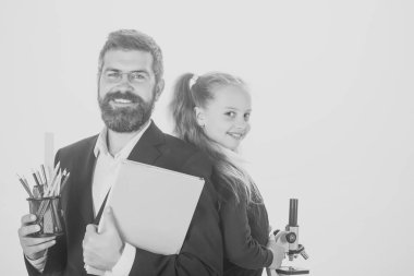 Kız ve erkek takım elbise ve okul üniforması. Eğitim ve okul kavramı dön. Çocuk ve öğretmen beyaz arka plan üzerinde izole mutlu yüzler ile mikroskop, kitap ve kalem öğretmen ve öğrenci tutun.