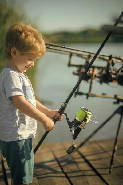 Sonrisa infantil con caña de pescar en muelle de madera — Foto de Stock