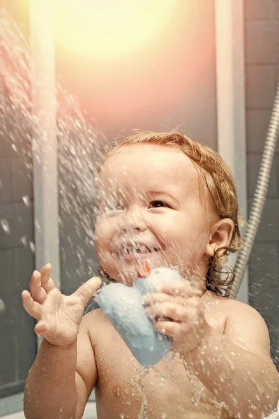 Chico feliz divirtiéndose. Sonriente niño en la ducha —  Fotos de Stock