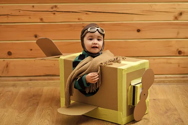 Little dreamer boy playing with a cardboard airplane — Stock Photo, Image