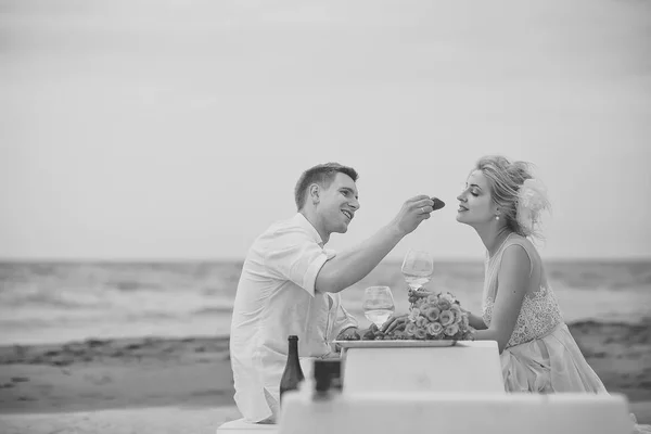 Una pareja romántica. Boda pareja comiendo en la playa — Foto de Stock