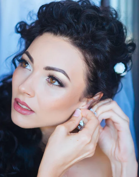 Şehvetli kadın düzeltme küpe. Şık saçlı esmer kadın. Glamour görünüm ve makyaj güzellik kız. Takı ile manken. Tatil ve parti hazırlığı.