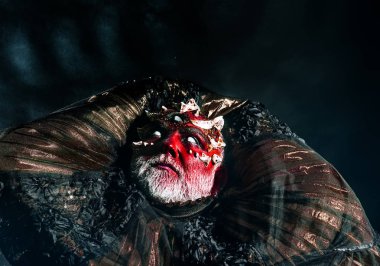 Kırmızı deri cehennemden yükselterek yanma ile şeytan. Canavar keskin dikenler ve siğiller yüz, korku ve hayal kavramı ile. Siyah arka plan, fantezi kostüm üzerine üç gözlü şeytan.