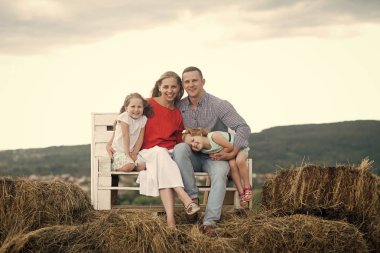 Çocuklar ve ebeveynler saman bankta oturmak