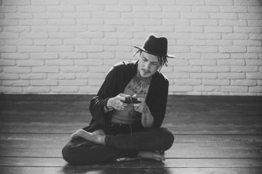 Moda model adam fece kapatın. Mutlu adam video konsolu elinde tutan adamla yüz