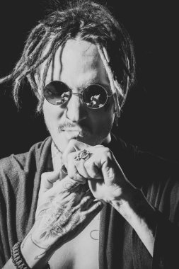 Yakışıklı adam yüz. Adam yasaktır boru siyah arka plan üzerine dövmeli elinde