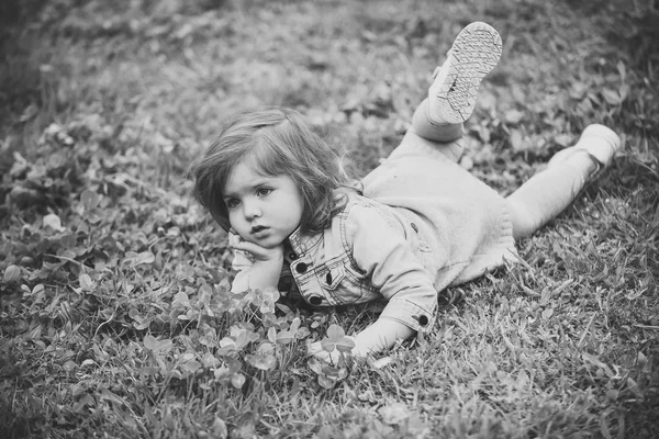 Barn spela - glad spel. Liten flicka på grönt gräs i parken — Stockfoto